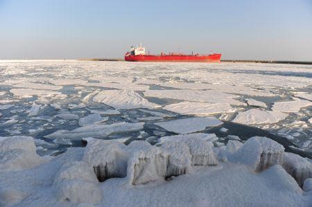 A vessel in berthed amid floating ice chunks in Laizhou Port of Laizhou City, east China's Shandong Province, Jan. 15, 2010. The worst sea ice in 30 years appeared from early January along the coastline of the Bohai Sea and the Yellow Sea as cold fronts pushed temperature to minus 10 degrees Celsius and below. By now over 40% of the sea surface of Bohai Sea has iced up. (Xinhua/Chu Yang)