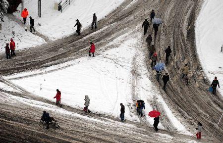 Pedestrians trudge through the snow in Zhengzhou, capital of central China's Henan Province, Nov. 12, 2009. Snowfall continued in most parts of north and northwest China on Thursday. (Xinhua/Wang Song)