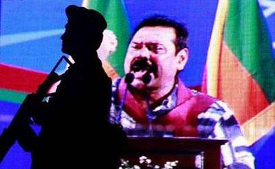 A soldier watches a crowd of supporters as Sri Lanka's President Rajapaksa specks at a final political rally for his presidential campaign in Piliyandala January 23, 2010. REUTERS/Dinuka Liyanawatte