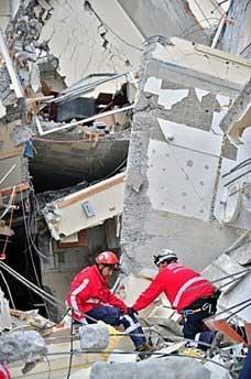 Rescue workers looks for victims in a wrecked building in Concepcion, Chile. (AFP/Martin Bernetti)