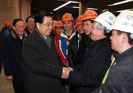 Hu Jintao (L front), general secretary of the Central Committee of the Communist Party of China, Chinese president and chairman of the Central Military Commission, shakes hands with workers and personnel who work for the construction of the Shanghai World Expo park in Shanghai, east China, Jan. 15, 2010. Hu Jintao paid a visit here to inspect the preparation of Shanghai World Expo on Jan. 15. (Xinhua/Ju Peng)