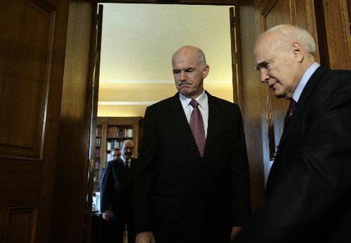 Greek Prime Minister George Papandreou (L) reported to President Karolos Papoulias on the new austerity measures to be taken in a bid to slash down the double-digit deficit by 4 percentage this year. (Xinhua/Marios Lolos)