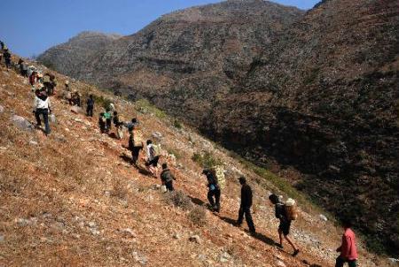 Villagers carry water back home from down the mountain in Huize County of Qujing City, southwest China's Yunnan Province, on March 7, 2010. Local villagers need to walk several kilometers down the mountain to fetch wather as the severe drought hit the province. At least 15 million people are affected by the shortage of drinking water in the worst-hit regions of Guizhou, Yunnan, Sichuan, Guangxi and Chongqing, according to the State Flood Control and Drought Relief Headquarters. (Xinhua/Qin Qing)