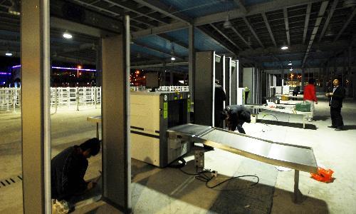 Workers set up security inspection facilities at the main entrance to the Pudong zone of the World Expo Park in Shanghai, east China, March 28, 2010. The Expo Park will soon start trial operation. (Xinhua Photo)