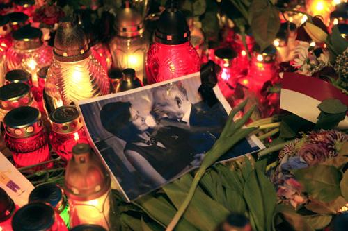 A photograph of Poland's late President Lech Kaczynski and his wife Maria is surrounded by candles and flowers near the presidential palace in Warsaw April 11, 2010. [Agencies] 