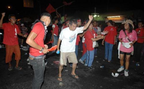 "Red-shirt"anti-government protesters gather after an explosion on Silom Road in the financial district of central Bangkok,capital of Thailand,April 22,2010 0.At least five people died and some 100 others were injured in a series of bomb blasts that hit Bangkok's main financial district of Silom on Thursday night,media sources said.(Xinhua/Shi Xianzhen)