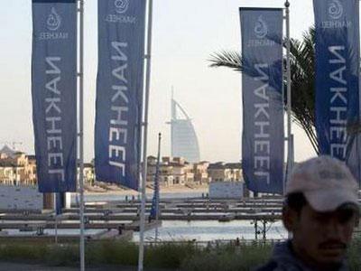 Nakheel company flags fly on Palm Jumeirah with Burj Arab in the background in Dubai December 14, 2009.REUTERS/Steve Crisp