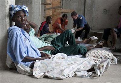 A woman waits after receiving medical treatment at a clinic in Leogane, Haiti on Tuesday Jan. 19, 2010. (AP Photo/The Canadian Press, Adrian Wyld)