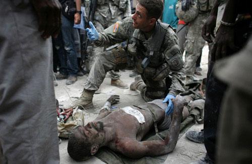 Rico Dibrivell, 35, is attended by a U.S. military rescue team member after being freed from the rubble of a building in Port-au-Prince January 26, 2010. (Xinhua/Reuters Photo)