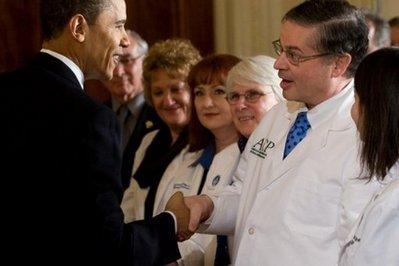 The fierce and escalating battle over health care reform has forced President Barack Obama, seen here with healthcare professionals on March 3, to delay his departure on a trip to Indonesia and Australia by three days until Sunday, March 21. (AFP/File/Saul Loeb) 