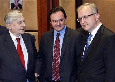 Greece's Finance Minister George Papaconstantinou is surrounded by European Central Bank (ECB) President Jean-Claude Trichet (L) and EU Economic Affairs Commissioner Olli Rehn (R) at the start of an Eurogroup finance ministers meeting at the EU Council in Brussels March 15, 2010. REUTERS/Francois Lenoir