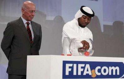 UAE national team player Ismail Mater collects a ball containing a team name beside former English soccer player Bobby Charlton during the 2009 FIFA Club World Cup official draw in Abu Dhabi November 12, 2009. REUTERS/Ahmed Jadallah(UNITED ARAB EMIRATES SPORT SOCCER)