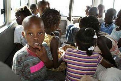 Children suspected of being involved in an illicit adoption scheme are seen in a local police car in Port-au-Prince January 30, 2010. REUTERS/Guy Delva