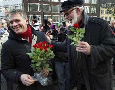 Netherlands' Finance Minister and Labor Party leader Wouter Bos (L) is seen handing out red roses to an unidentified man at a city council election meeting in Utrecht February 20, 2010. REUTERS/Michael Kooren