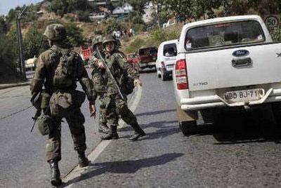 Chilean soldiers try to maintain order as residents drive hurriedly away from the coast to higher ground after a tsunami warning was issued following a strong aftershock, in Constitucion, March 3, 2010. REUTERS/Ivan Alvarado