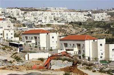 An excavator works near houses under construction in the West Bank Jewish settlement of Beitar Ilit, near Bethlehem March 8, 2010. REUTERS/Amir Cohen