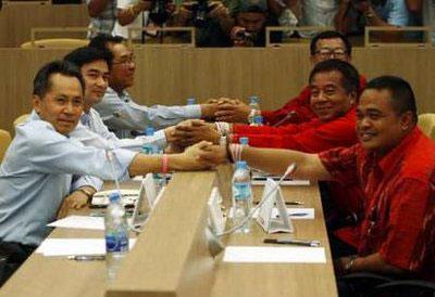 Thai Prime Minister Abhisit Vejjajiva (2nd L) shakes hands with the leader of the United Front for Democracy Against Dictatorship (UDD) Veera Musikapong during a meeting at an academic institute in Bangkok March 28, 2010. REUTERS/Chaiwat Subprasom