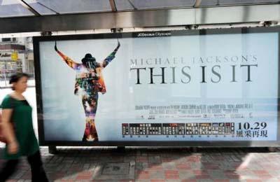 A local citizen passes by a poster of Michael Jackson's This is It in Hong Kong, Oct. 28, 2009. The premiere of This is It will fall on Tuesday. (Xinhua/Song Zhenping)