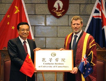 Visiting Chinese Vice Premier Li Keqiang (L) gives the tablet to Rod Carr, Vice-Chancellor of University of Canterbury, during the inauguration of Confucius Institute of University of Canterbury in Christchurch, New Zealand, Nov. 1, 2009.(Xinhua/Liu Jiansheng)