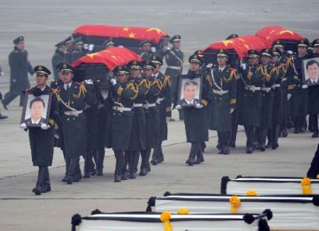 Soldiers carry the coffins of the eight peacekeeping police officers who died in the Haiti earthquake at the airport in Beijing, China, Jan.19,2010.(Xinhua/Jin Liangkuai)