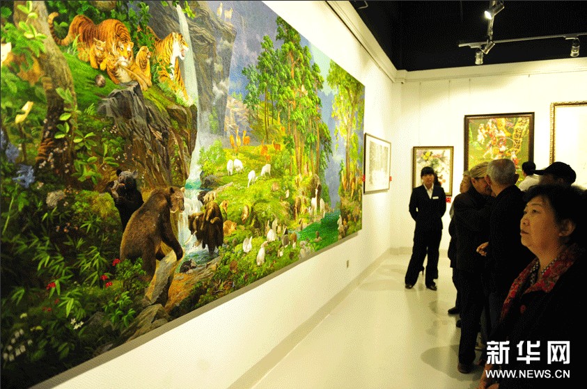 參觀者在欣賞朝鮮刺繡作品《動物花園》