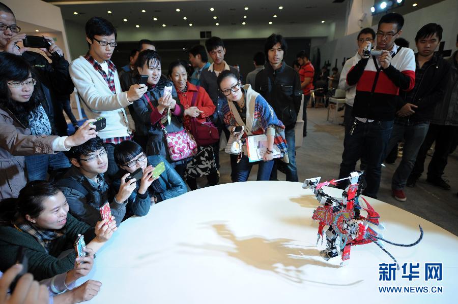 11月1日，參觀者被一個穿著京劇服裝的倣人機器人的表演所吸引。當日，由中國人工智慧學會和杭州市政府主辦的以“智慧體驗智慧生活”為主題的2012第二屆中國智慧博覽會在浙江世貿國際展覽中心開幕。新華社記者 鞠煥宗 攝 