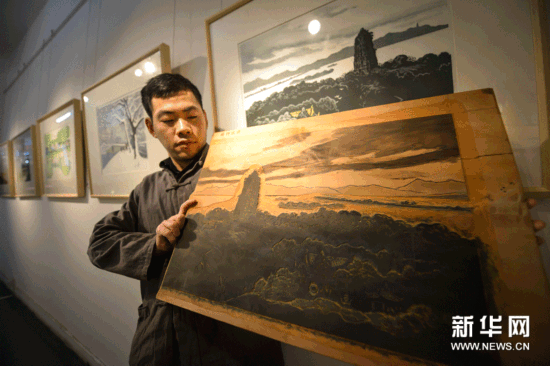 （4）12月18日，工作人員在展示反映西湖“雷峰夕照”景色的水印木刻作品《晚鐘遠逝》以及木刻版。
