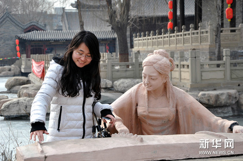 2月23日，在榆次老城新春蠟像展上，一名遊客在模倣“蠟人”的彈琴動作。新華網圖片 王飛航 攝