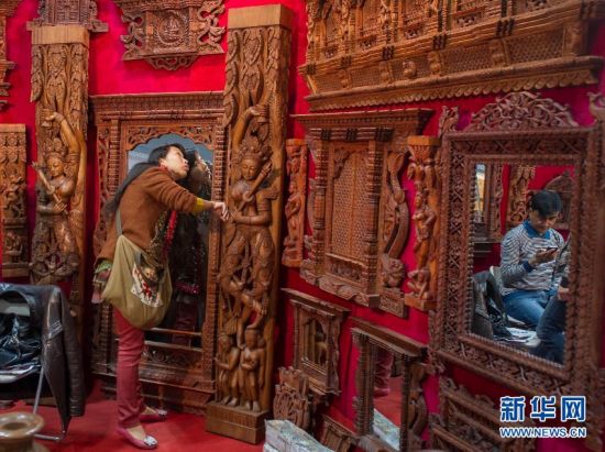 2月28日，參觀者在展會上欣賞來自尼泊爾的木製品。