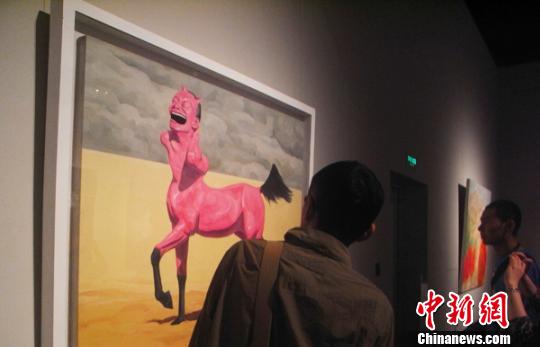書畫愛好者駐足觀賞當代藝術家岳敏君的布面油畫《阿拉伯馬》。　盛捷　攝