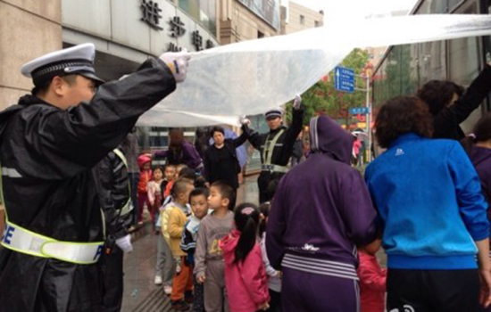 大連交警雨中為200名幼兒遮風擋雨