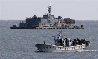 FILE - In this Nov. 17, 2009, file photo, a South Korean fishing boat passes by the South Korean Navy's floating base near South Korea's western Yeonpyong Island, near the disputed sea border with North Korea. North Korea declared waters along its disputed sea border with South Korea a 'firing zone' Monday Dec. 21, 2009, and warned ships from the South to stay away from the area, which was the scene of a deadly clash last month.(AP Photo/Yonhap, Choi Jae-gu, File)