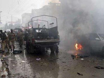 Soldiers walk past a damaged military vehicle after it was hit by a bomb in Mingora, located in Pakistan's restive North West Frontier Province, February 22, 2010. A suspected suicide bomber killed six people in an attack on a security forces convoy in a market in the main town of Pakistan's Swat valley on Monday, police said.REUTERS/Hazrat Ali Bacha (PAKISTAN - Tags: POLITICS CIVIL UNREST CRIME LAW)