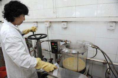 A medical staff is seen preparing the Chinese herbal medication "Jin Hua Qing Gan Fang" for the treatment of A/H1N1 flu in Dongzhimen Hospital, Beijing, China on Thursday, December 17, 2009. [Photo: the Beijing Times/Zhou Min/CFP]