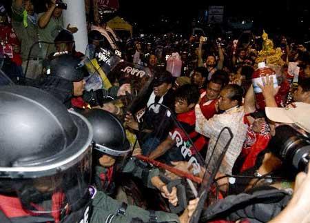 Thai red-shirted demonstrators clash with policemen as they try to pour blood on the footpath in front of the ruling Democrat Party's headquarters in Bangkok, capital of Thailand, March 16, 2010. (Xinhua/Lui Siu Wai)