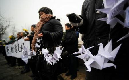 Mourners wait for the arrival of the coffins of the eight peacekeeping police officers who were killed in the Haiti earthquake in a crossing linking to the Babaoshan Revolutionary Cemetery in Beijing, Jan. 19, 2010. The coffins of the eight peacekeeping police officers are to be brought here on Tuesday. (Xinhua/Wang Jianhua)