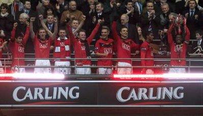 Manchester United's Patrice Evra (R) lifts the League Cup trophy after winning their English League Cup final soccer match against Aston Villa at Wembley Stadium in London February 28, 2010. REUTERS/ Eddie Keogh 