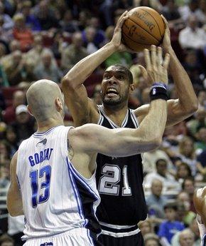 San Antonio Spurs center Tim Duncan (21) goes up for a jump shot over Orlando Magic center Marcin Gortat (13), of Poland, during the first half of an NBA basketball game in Orlando, Fla., Wednesday, March 17, 2010.(AP Photo/John Raoux)