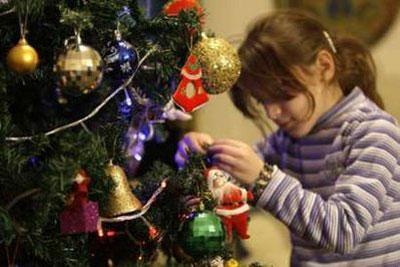 A girl decorates a Christmas tree at her house in Baghdad December 22, 2009. Picture taken December 22, 2009.REUTERS/Saad Shalash