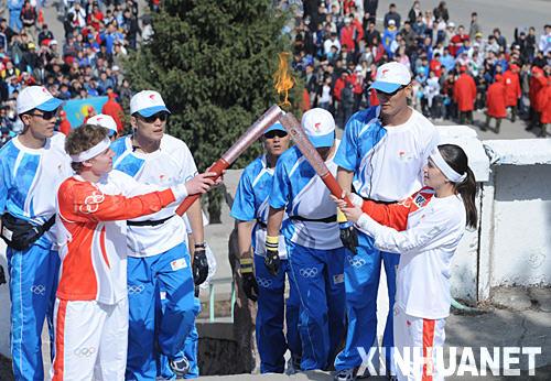 4月2日，奧運火炬手、哈薩克斯坦游泳運動員拉博塔（前左）與火炬手扎米利亞進行火炬交接。當日，北京奧運會聖火傳遞活動在哈薩克斯坦阿拉木圖市拉開帷幕。阿拉木圖是北京奧運聖火傳遞境外傳遞的第一站。 新華社記者安治平攝