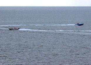 This image released by the U.S Navy Tuesday, Jan. 8, 2008, and shot Sunday, Jan. 6 from the bridge of the destroyer USS Hopper, shows 2 small boats, alleged to be Iranian, purportedly racing near the wake of U.S. Navy ships in the Persian Gulf.   (Xinhua/AFP Photo)