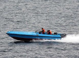 This image released by the U.S. Navy Tuesday, Jan. 8, 2008, and shot Sunday, Jan. 6 from the bridge of the destroyer USS Hopper, shows a small blue boat, alleged to be Iranian, purportedly racing near the wake of U.S. Navy ships in the Persian Gulf.  (Xinhua/AFP Photo)