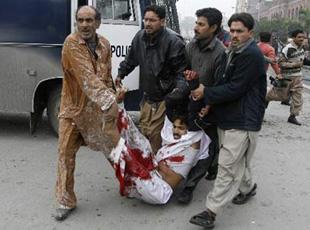 Police carry a colleague injured in a suicide bombingoutside a court in the centre of Lahore Jan. 10, 2008. (Xinhua/Reuters Photo)