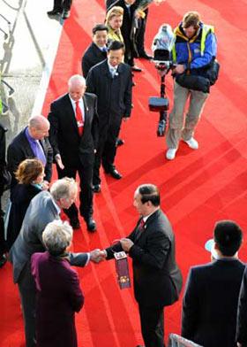 Jiang Xiaoyu (Front,R2), the executive vice president of the Beijing Organizing Committee for the 2008 Olympic Games (BOCOG), greets the representatives of London with the lantern which holds the Olympic flame in his hands at the airport in London, capital of Britain, April 5, 2008. (Xinhua/Zhou Wenjie) 