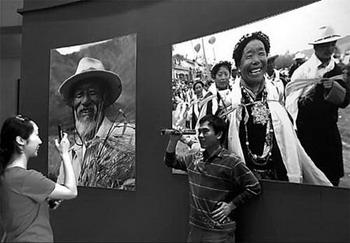 Visitors take pictures at the exhibition "Tibet of China: Past and Present" yesterday at the Cultural Palace of Nationalities in Beijing. The exhibition opened on Wednesday and will run untill July 25.(Photo: China Daily)