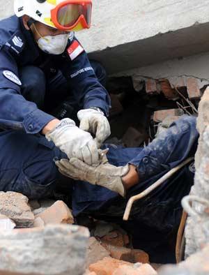 Members of a rescue team from Singapore search for survivors in the quake-hit Hongbai Town of Shifang City in southwest China's Sichuan Province, May 17, 2008. The team of 55 members from Singapore started their rescue mission in the serious devastated Hongbai Town on Saturday.(Xinhua/Jiang Fan) 