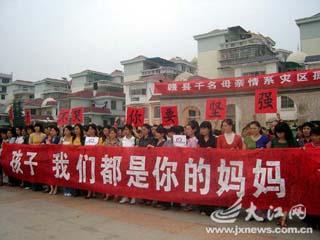 More than 1,000 mothers sign their names on a red scroll that displays the message 