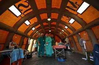 Two Russian surgeons pat each other self-congratulating on successfully winding up their second surgical operation at the quake-ravaged Pengzhou City, southwest China's Sichuan Province, May 21, 2008. The Russian medical team carried out surgical operations at the inflatable mobile hospital, comprising surgery rooms, patients' ward and other relevant facilities on Wednesday morning. (Xinhua Photo)