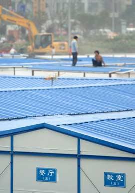 Workers build makeshift shelters for quake survivors at a temporary resettlement zone in Dujiangyan City of southwest China's Sichuan Province, on May 27, 2008. Up to May 26, a total of 8,152 makeshift shelters were built in quake-affected areas. Among the makeshift shelters, 7,263 of them were built by Sichuan Province, 712 under the assistance of other provinces and 177 by community donations.(Xinhua/Yue Yuewei)