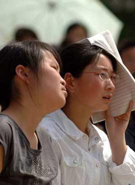 Grade 3 high school students attend classe despite the hot weather in the quake-hit Ningqiang County, Shaanxi Province, northwest China, May 28, 2008. Some dormitory tents and classroom tents were set up on the playground of the No. 1 Middle School of Ningqiang for more than 1100 grade 3 students in order to ensure their preparation for the upcoming national college entrance examinations. (Xinhua/Chen Gang)